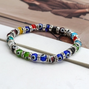 Close-up of colorful evil eye beaded bracelet with sparkling crystal spacers on white surface