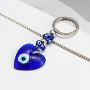 Detail of blue glass evil eye heart pendant keychain with metal ring and decorative beads