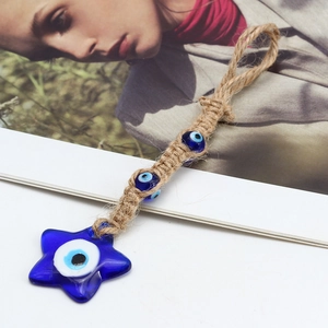 Macro shot of blue glass star Evil Eye pendant with handmade braided rope detail
