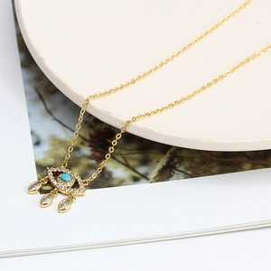 Détail du collier œil protecteur doré avec pierre bleue et oxydes de zirconium blancs