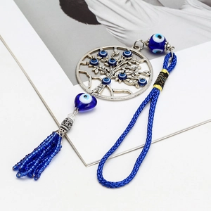 Détail de l'amulette arbre de vie œil grec avec pompon bleu et cœur en cristal
