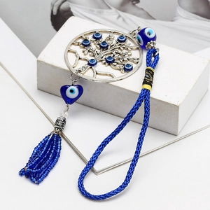 Détail du pendentif arbre de vie avec perles en verre œil bleu et pompon bleu