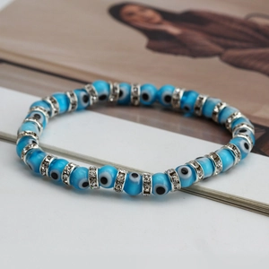 Macro shot of blue Evil Eye beads with sparkling crystal spacers on a fashion magazine