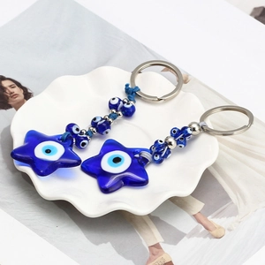 Evil Eye Pentagram Keychain set with deep blue glass charm and silver metal ring on white tray
