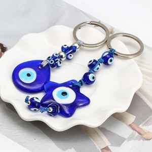 Detail of blue Nazar Evil Eye keychain set with star and teardrop pendants in a dish