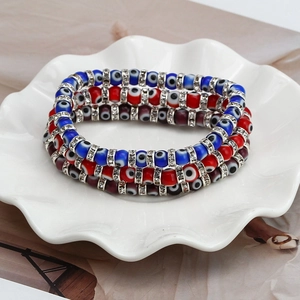 Close-up of three Evil Eye beaded elastic bracelets with rhinestones in a ceramic dish