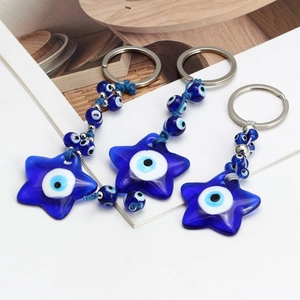 Detail of blue star-shaped evil eye keychains with resin charms and silver metal ring