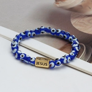 Blue Evil Eye beaded bracelet with a gold metal Jesus bead on a minimal background