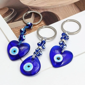 Detailed view of blue glass Evil Eye charms with heart pendants and woven rope keychain