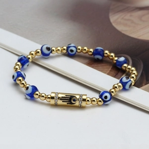 Detail of beaded evil eye bracelet with Hamsa Hand charm and blue glass beads