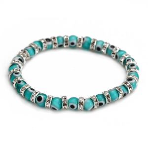 Macro detail of Turkish blue Evil Eye beads and silver rhinestone spacers on elastic bracelet