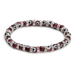 Macro shot of dark red Evil Eye beads with sparkling crystal spacers on elastic bracelet