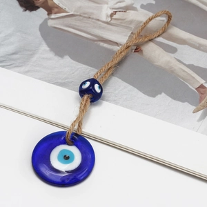 Macro detail of the evil eye glass pendant with natural jute rope on a clean background