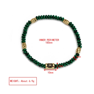Detail of beaded evil eye bracelet featuring green malachite beads and golden accents