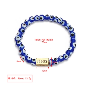 Detailed close-up of blue Evil Eye beads bracelet with engraved Jesus metal charm