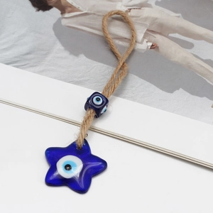 Detailed macro view of the handmade blue glass star and the evil eye bead on jute rope
