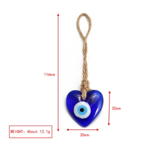 Detail view of heart-shaped blue evil eye glass charm with brown jute rope and dimensions