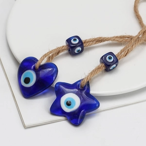 Detail of blue glass Nazar amulets in heart and star shapes with natural jute rope