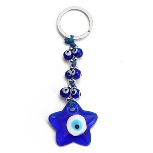 Detail view of a blue star-shaped Evil Eye keychain with small glass beads and metal ring