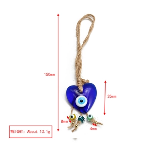 Macro view of blue heart-shaped glass Evil Eye pendant with colorful beads and jute rope cord