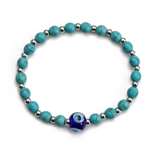Detailed macro view of synthetic turquoise beads and central evil eye charm on bracelet
