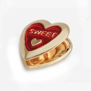Gouden hartvormige hanger met rood email en Sweet-gravure op een witte achtergrond