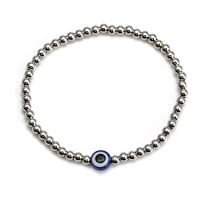 Detailed macro shot of silver beaded bracelet featuring a blue evil eye charm on white backdrop