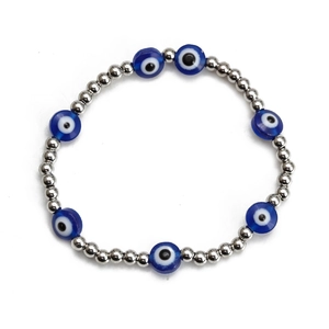 Detail of silver beads and blue glass Evil Eye charms on an elastic beaded bracelet