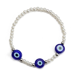 Detailed macro view of white beaded evil eye stretch bracelet with blue glass charms