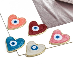 Detail of five colorful enamel heart pendants with evil eye charms and gold metal plating