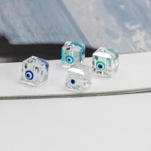 Macro detail of faceted glass square beads with evil eye design for DIY jewelry making
