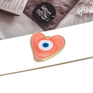 Detailed macro view of heart-shaped marble pendant with gold trim and evil eye design