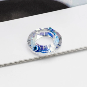 Macro shot of faceted clear crystal evil eye charm for DIY jewelry necklace design
