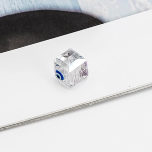 Macro detail of a transparent cubic crystal bead with evil eye design for DIY jewelry