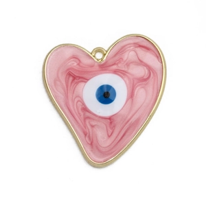 Macro detail of heart-shaped gold alloy pendant with pink marble texture and evil eye design