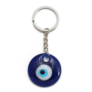 Macro shot of blue Evil Eye keychain pendant with silver metal ring on white background