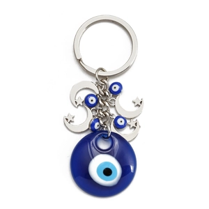 Detail of blue evil eye keychain featuring silver crescent moon and star charms