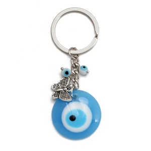 Dettaglio dell'anello portachiavi malocchio con perla blu nazar e ciondolo a farfalla