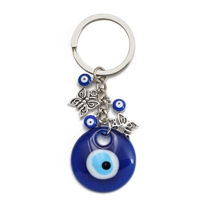 Detail of blue Evil Eye keychain with silver butterfly charms and glass bead accents