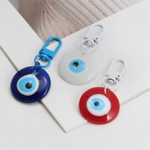 Three-piece Evil Eye resin keychain set in dark blue, white, and red with plastic clips