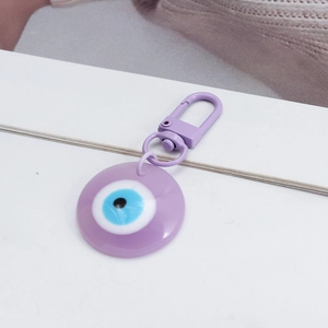 Purple Evil Eye keychain made of resin with a metallic spring clasp on white background