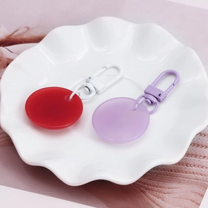 Minimalist red and purple evil eye keychains in a white ceramic dish with lobster clasps