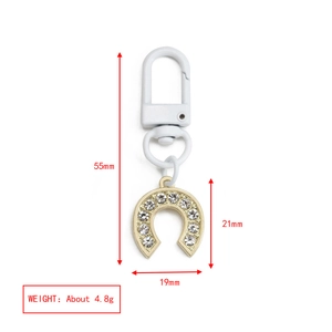 Detail showing dimensions and 4.8g weight of horseshoe evil eye keychain with white crystals
