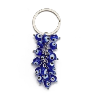 Macro view of Turkish evil eye keychain beads with deep blue glass eyes and silver ring