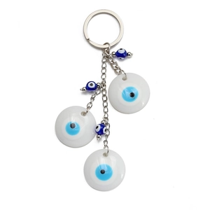 Detail of evil eye keychain with blue beads and white concentric disc pendants