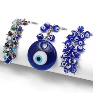 Blue glass evil eye keychain and pendant set with silver chain on white stand