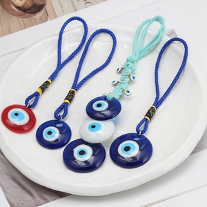 Close-up of four assorted blue evil eye glass charms on a decorative white plate
