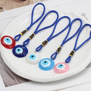 Detail of colorful Evil Eye charms with deep blue braided ropes and circular pendants