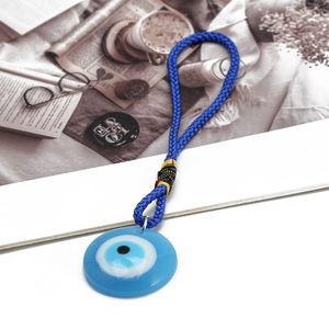 Detailed view of handcrafted blue evil eye circular pendant with woven blue cord