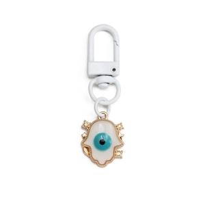 Macro detail of Hamsa Hand keychain with blue evil eye and white enamel finish